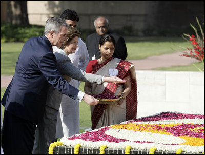 President George W. Bush and Laura Bush sprinkle flowers on the south side of the Mahatma Gandhi Memorial Thursday, March 2, 2006, during a wreath-laying ceremony in Rajghat, India.