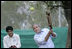 President George W. Bush watches his hit during a cricket clinic with Pakistani youth from the Schola Nova school and the Islamabad College for Boys, Saturday, March 4, 2006, at the Raphel Memorial Gardens on the grounds of the U.S. Embassy in Islamabad, Pakistan.