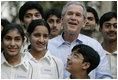 President George W. Bush poses with Pakistani youth from the Schola Nova school and the Islamabad College for Boys, Saturday, March 4, 2006, at the Raphel Memorial Gardens on the grounds of the U.S. Embassy in Islamabad, Pakistan, following his participation in a cricket clinic.