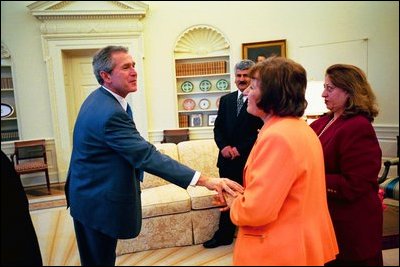 President George W. Bush shakes hands with a survivor of a chemical weapons attack in Halabja, a Kurdish village in Northern Iraq, during an Oval Office meeting March 14, 2003. The attack killed 5,000 people. 