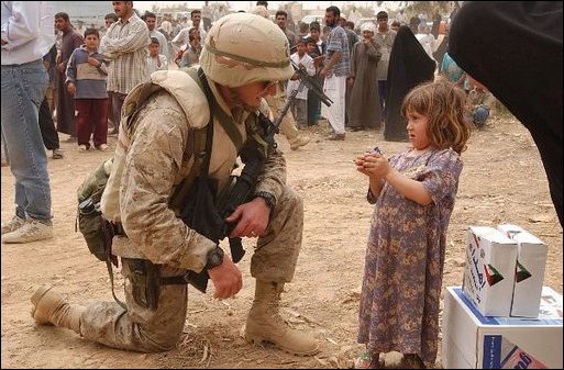 U.S. Marine Corps Major Chris Hughes shares some time with an Iraqi girl during an effort to distribute food and water to Iraqi citizens in need.