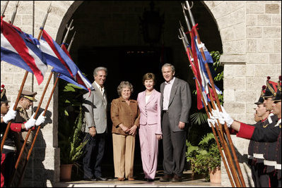 President George W. Bush and Laura Bush join President Tabare Vazquez of Uruguay, and his wife, Mrs. Maria Auxiliadora Delgado de Vazquez in the entrance of the ranch house at Estancia Anchorena. The visit to the Latin American country was the second leg of a five-country South American and Central America visit for the President and Mrs. Bush. White House photo by Paul Morse