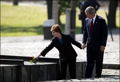 President George W. Bush and Mrs. Bush place a rose at the end of the railroad tracks at the Birkenau concentration camp in Poland, Saturday, May 31, 2003. White House photo by Paul Morse