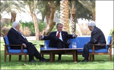President George W. Bush, center, discusses the Middle East peace process with Prime Minister Ariel Sharon of Israel, left, and Palestinian Prime Minister Mahmoud Abbas in Aqaba, Jordan, Wednesday, June 4, 2003. White House photo by Paul Morse