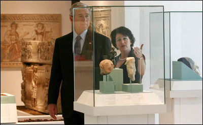 President George W. Bush listens as Amanda Weiss, Director of Bible Lands Museum Jerusalem describes and exhibit Friday, May 16, 2008, during a tour of the museum by the President and Mrs. Laura Bush.