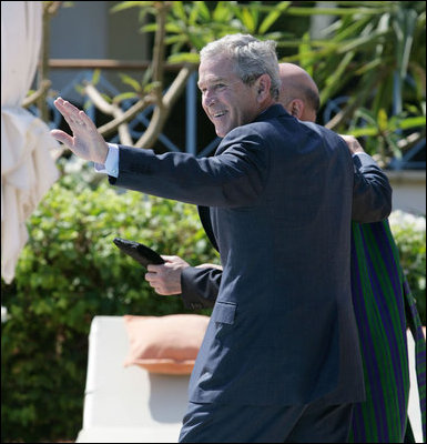 President George W. Bush waves as he walks with Afghanistan President Hamid Karzai Saturday, May 17, 2008, following their meeting with members of the media in Sharm el-Shiek, Egypt.