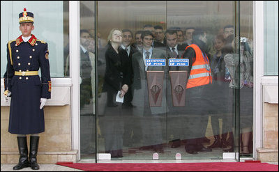 A crowd gathers inside the doors to watch as President George W. Bush and Mrs. Laura Bush arrive at the Henri Coanda International Airport Tuesday, April 1, 2008, in Bucharest, Romania.