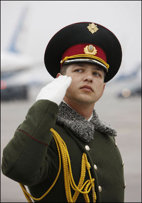 A member of the honor guard salutes as President George W. Bush and Mrs. Laura Bush prepare to depart Kyiv's Boryspil State International Airport Tuesday, April 1, 2008, after spending a daylong visit in Ukraine before continuing on to Bucharest, site of the 2008 NATO Summit.