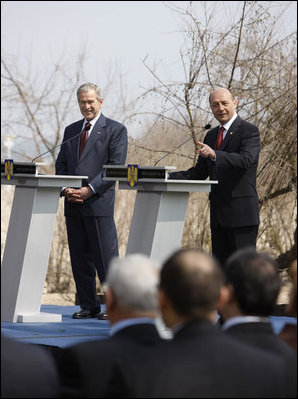 President George W. Bush smiles as he listens to a response to a reporter's question by President Traian Basescu of Romania, during a joint press availability Wednesday, April 2, 2008, at the presidential retreat in Neptun, Romania.