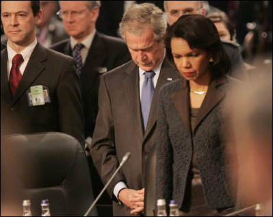 President George W. Bush bows his head as he stands with Secretary of State Condoleezza Rice Thursday, April 3, 2008, at the start of the North Atlantic Council Summit in Bucharest.