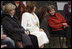 Mrs. Laura Bush leans in to listen to Alexandra Coman, fiance of Romania's Foreign Minister Adrian Cioroianu, as they join other guests, including Mrs. Maria Basescu, in white, spouse of Romania's President Taian Basescu, and Mrs. Jeannie de Hoop Scheffer, spouse of NATO Secretary General Jaap de Hoop Scheffer, at the Dimitrie Gusti Village museum in Bucharest.