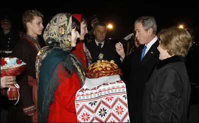 President George W. Bush acknowledges the taste of bread -- presented as a traditional Ukrainian welcome -- as he and Mrs. Laura Bush are greeted upon their arrival Monday, March 31, 2008, at Boryspil State International Airport in Kyiv.