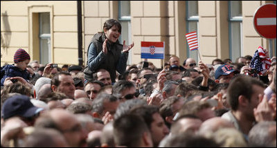 A young girl, atop the shoulders of a friend to get a better view, applauds in the crowd at Zagreb's St. Mark's Square as President George W. Bush addresses the thousands who turned out to welcome him Saturday April 5, 2008.