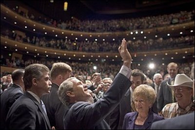 President George W. Bush waves to people in the balconies after participating in a conversation on strengthening Social Security at the Cannon Center for the Performing Arts in Memphis, Tenn., Friday, March 11, 2005.