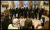 President George W. Bush and the crew members of the Space Shuttle Discovery (STS-114) pose for news photographers in the Oval Office at the White House, Wednesday, Feb. 22, 2006. The STS-114 crew was the first U.S. Space Shuttle flight, July 26, 2005, since the February 2003 loss of the Space Shuttle Columbia.