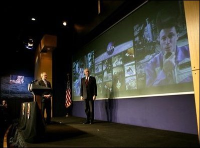 President George W. Bush and NASA Administrator Sean O'Keefe watch as Michael Foale, right, commander of the International Space Station welcomes the President during a live television link from space at NASA headquarters in Washington, D.C., Wednesday, Jan. 14, 2004.