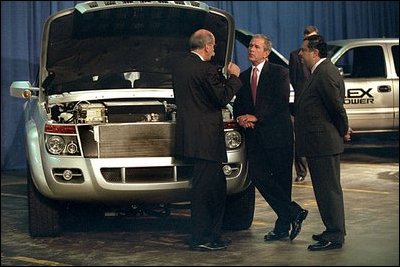 President Bush and Energy Secretary Spencer Abraham, right, tour an exhibit of hybrid electric-fuel cars and trucks at the Department of Energy in Washington, D.C., June 28, 2001. 