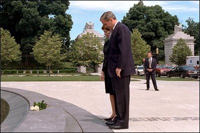 President George W. Bush and Laura Bush observe a moment of silence after laying flowers at the fountain by the entrance of Arlington National Cemetery May 28, 2001.