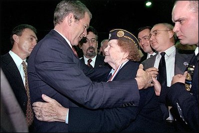 Attending the Veterans Day Prayer Breakfast at Park Avenue Seventh Regiment Armory in New York Nov. 11, President George W. Bush embraces Arlene Howard, who gave President Bush the badge from her son, George Howard, a Port Authority police officer who died at the World Trade Center. 