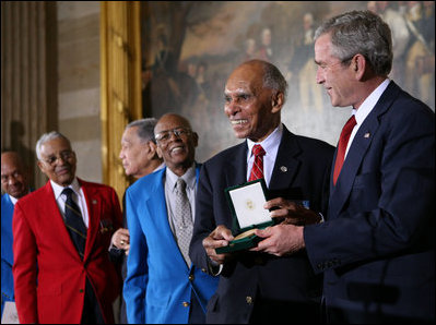 President George W. Bush presents the Congressional Gold Medal Dr. Roscoe Brown Jr., during ceremonies honoring the Tuskegee Airmen Thursday, March 29, 2007, at the U.S. Capitol. Dr. Brown, Director of the Center for Urban Education Policy and University Professor at the Graduate School and University Center of the City University of New York, commanded the 100th Fighter Squadron of the 332 Fighter Group during World War II. White House photo by Eric Draper