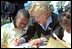 A second grade boy looks on as Mrs. Cheney demonstrates how the founding fathers used quill pens to sign the U.S. Constitution during Constitution Day at the Naval Observatory Sept. 17, 2002. In additions to signing the Constitution, children also learned about 18th century coins and making coin rubbings, created tricorn hats like those worn in the 1700s and played Constitution-era games.