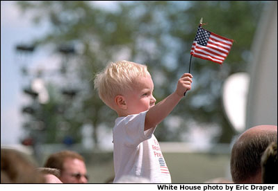 Photo of young boy holding an American flag. White House photo by Eric Draper.