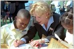 A second grade boy looks on as Mrs. Cheney demonstrates how the founding fathers used quill pens to sign the U.S. Constitution during Constitution Day at the Naval Observatory Sept. 17, 2002. In additions to signing the Constitution, children also learned about 18th century coins and making coin rubbings, created tricorn hats like those worn in the 1700s and played Constitution-era games.
