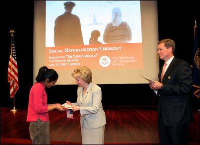 Mrs. Lynne Cheney hands out a copy of “The Citizen’s Almanac,” during a special naturalization ceremony at the National Archives Tuesday, April 17, 2007, in Washington, D.C. White House photo by Lynden Steele
