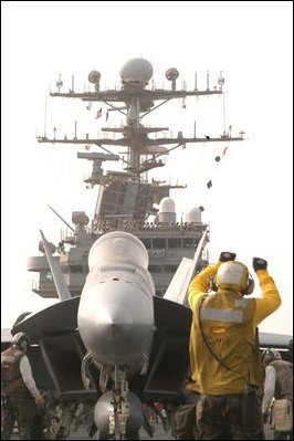 The Arabian Gulf (Mar. 20, 2003) -- An Aviation Boatswain's Mate directs an F/A-18E Super Hornet assigned to the “Eagles” of Strike Fighter Squadron One One Five (VFA 115), prior to launching the aircraft from the flight deck aboard the aircraft carrier USS Abraham Lincoln (CVN 72). U.S. Navy photo by Photographer's Mate 3rd Class Tyler Clements