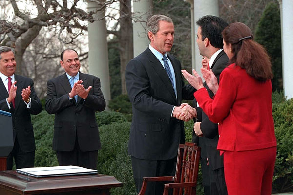 President George W. Bush signs papers with Latino leaders during a ceremony transmitting his tax cut proposal to Congress in the Rose Garden of the White House