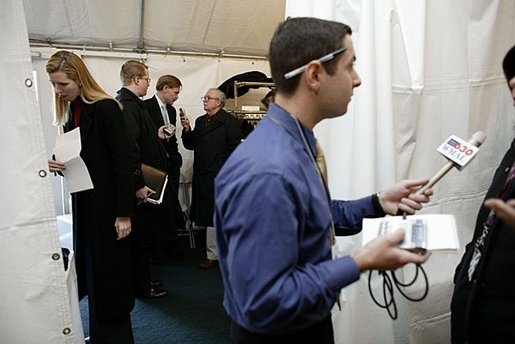 As reporters roam through the tent, U.S. Trade Representative Robert Zoellick takes part in an interview during the Radio Day at the White House Wednesday, Jan. 21, 2004. White House photo by Paul Morse.