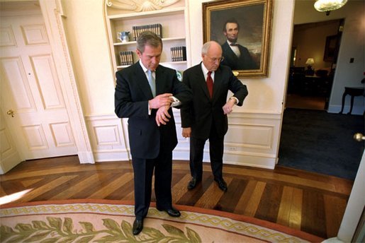 President George W. Bush and Vice President Cheney check the time after the swearing-in ceremony for Secretary of State Colin Powell in the Oval Office Jan. 26, 2001. White House photo by Eric Draper.