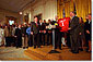 The Univerity of Oklahoma football team presents President George W. Bush with a jersey in the East Room of the White House on March 5, 2000. WHITE HOUSE PHOTO BY ERIC DRAPER
