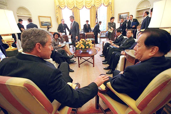 Pictured is President Bush talking with the Vice Premier of China Qian Qichen in the Oval Office. Both are seated in front of the mantel.