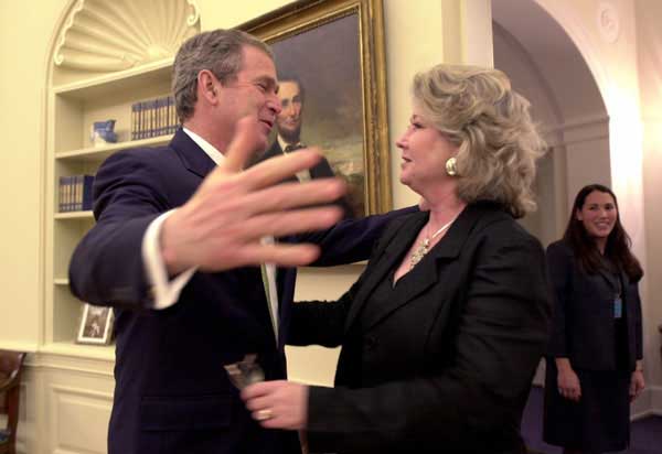 President George W. Bush hugs Katha Black, National PTA Outstanding Teacher of the Year during an oval office visit, Thursday, March 15. Also pictured is White House Staffer Anne Trenolone, at right. 