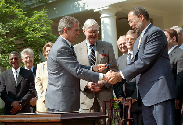 "Social Security is one of the greatest achievements of the American government, and one of the deepest commitments to the American people," said President George W. Bush during his announcement of a Presidential Commission for Social Security in the Rose Garden May 2. As the commission's new co-chairman Sen. Daniel Patrick Moynihan of New York applauds the signing of the executive order, President Bush gives the pen he used to the otherco-chairman Richard D. Parsons, Co-Chief Operating Officer of AOL Time Warner. White House photo by Eric Draper.