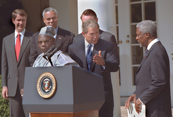 President George W. Bush welcomes UN Secretary General Kofi Annan to the podium after his announcement of Presidential HIV/AIDS Trust Fund Initiative as Nigerian President Olusegun Obsanjo looks on at left in the Rose Garden, Friday, May 11. WHITE HOUSE PHOTO BY ERIC DRAPER