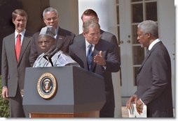 President George W. Bush welcomes UN Secretary General Kofi Annan to the podium after his announcement of Presidential HIV/AIDS Trust Fund Initiative as Nigerian President Olusegun Obsanjo looks on at left in the Rose Garden, Friday, May 11.  White House photo by Eric Draper