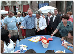 Arm in arm with Philadelphia Mayor John Street, President Bush passes out birthday cake at an urban block party in Philadelphia July 4, 2001. The President celebrates his 55th birthday July 6, 2001.