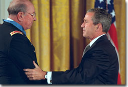 President Bush drapes the Congressional Medal of Honor on Ed Freeman of Boise, Idaho, in the East Room at the White House Monday, July 16, 2001. Mr. Freeman was awarded the honor for his actions in 1965 when, as a helicopter pilot during, he flew through gunfire more than 20 times during a single, ferocious battle, bringing supplies to a trapped batallion and flying more than 70 wounded soldiers to safety. White House photo by Paul Morse.