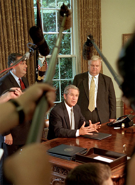 President Bush, Secretary of Energy Spencer Abraham (left) and economic advisor Larry Lindsey speak with the media in the Oval Office before the President signed an executive order that sets a standard of energy efficiency July 31, 2001. 