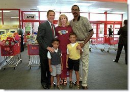 After talking with several families about how far $600 can go during family shopping trips, President Bush poses for pictures with one of the families just outside the Target Snack Bar at a retail location in Kansas City, Mo., Aug. 21, 2001.  White House photo by Moreen Ishikawa