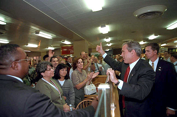 President George Bush gives a thumbs up to a crowded cafeteria while visiting the Pentagon September 17. After meetings, the President talked with hundreds of employees throughout the complex. White House photo by Eric Draper.