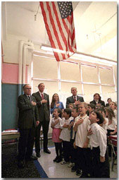 Accompanied by a chorus of little and big voices, President Bush says "The Pledge of Allegiance," at an elementary school during his visit to New York Oct. 3. White House photo by Paul Morse.