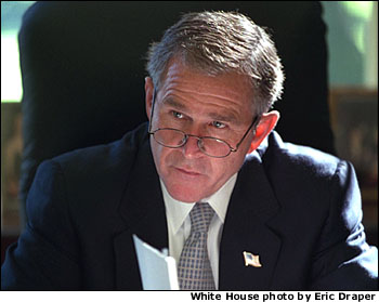 Working at his desk in the Oval Office, President George W. Bush prepares for his first meeting with the Homeland Security Team Oct. 29, 2001. White House photo by Eric Draper.