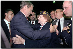 Attending the Veterans Day Prayer Breakfast at Park Avenue Seventh Regiment Armory in New York Nov. 11, President George W. Bush embraces Arlene Howard, who gave President Bush the badge from her son, George Howard, a Port Authority police officer who died at the World Trade Center. White House photo by Paul Morse.