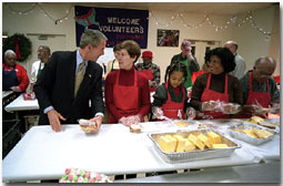 Visiting "Martha's Table" center for homeless adults and children, President George W. Bush talks with volunteer Connie Jeremiah December 20. The president helped pack sandwiches into carrying crates at the center which has been providing food to the hungry since 1980. White House photo by Eric Draper.