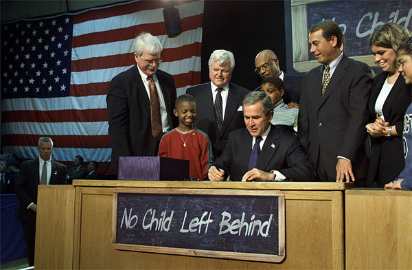 Visiting Hamilton High School in Hamilton, Ohio, Jan. 8, President George W. Bush signs into law historic, bi-partisan education legislation. On hand for the signing are Democratic Rep. George Miller of California (far left), Democratic U.S. Sen. Edward Kennedy of Massachusetts (center, left), Secretary of Education Rod Paige (center, behind President Bush), Republican Rep. John Boehner of Ohio, and Republican Sen. Judd Gregg of New Hampshire (not pictured). White House photo by Paul Morse.