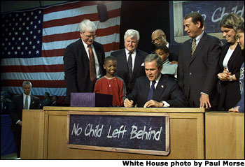 Visiting Hamilton High School in Hamilton, Ohio, Jan. 8, President George W. Bush signs into law historic, bipartisan education legislation. On hand for the signing are Democratic Rep. George Miller of California (far left), Democratic U.S. Sen. Edward Kennedy of Massachusetts (center, left), Secretary of Education Rod Paige (center, behind President Bush), Republican Rep. John Boehner of Ohio, and Republican Sen. Judd Gregg of New Hampshire (not pictured). White House photo by Paul Morse.
