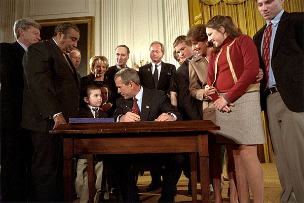 President George W. Bush looks over to Thomas Martello, 6, during the signing ceremony of the Victims of Terrorism Tax Relief Act in the East Room Jan. 23. "We're joined today by families who have lost loved ones in the great acts of evil," said the President. "As you draw on faith and personal strength to cope with your grief, I hope you'll also find comfort in the knowledge that your nation stands with you and prays for you. We mourn those whom we've lost, and we face the future together." White House photo by Eric Draper.